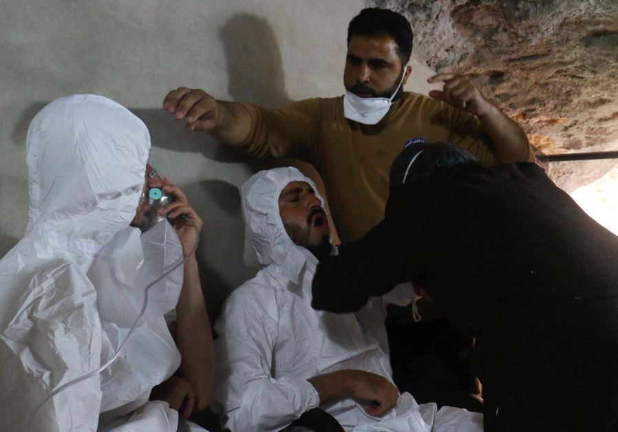 A man breathes through an oxygen mask as another one receives treatments, after what rescue workers described as a suspected gas attack in the town of Khan Sheikhoun in rebel-held Idlib, Syria April 4, 2017