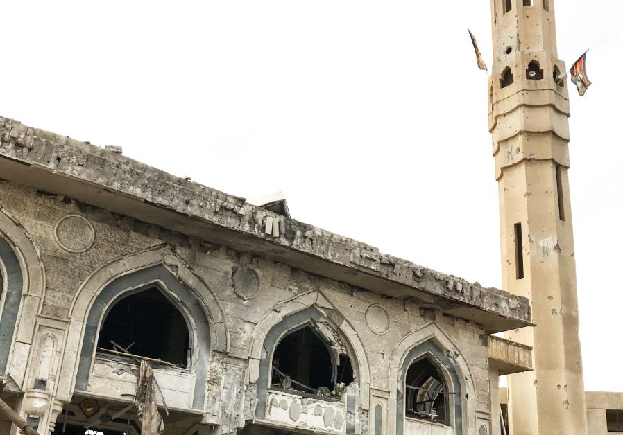 Shia militia flags hang from a mosque in Mosul