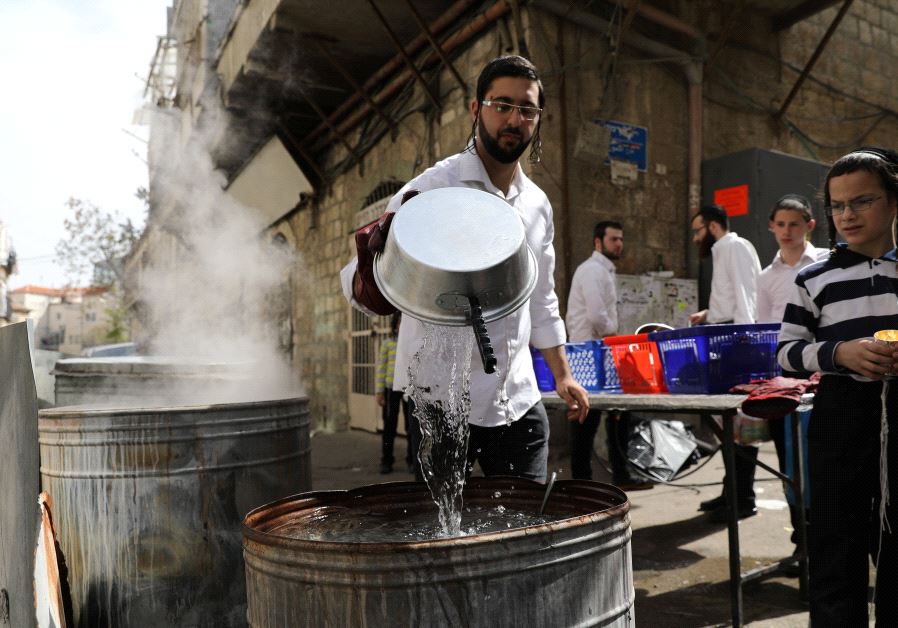 Ultra-Orthodox Jewish men sort their cooking utensils at they dip them in boiling water to remove remains of leaven in preparation for the Jewish holiday of Passover, in Jerusalem's Mea Shearim neighbourhood April 9, 2017