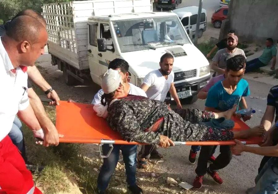 A wounded man is treated at the scene of violent clashes between settlers and Palestinians in the Yitzhar settlement