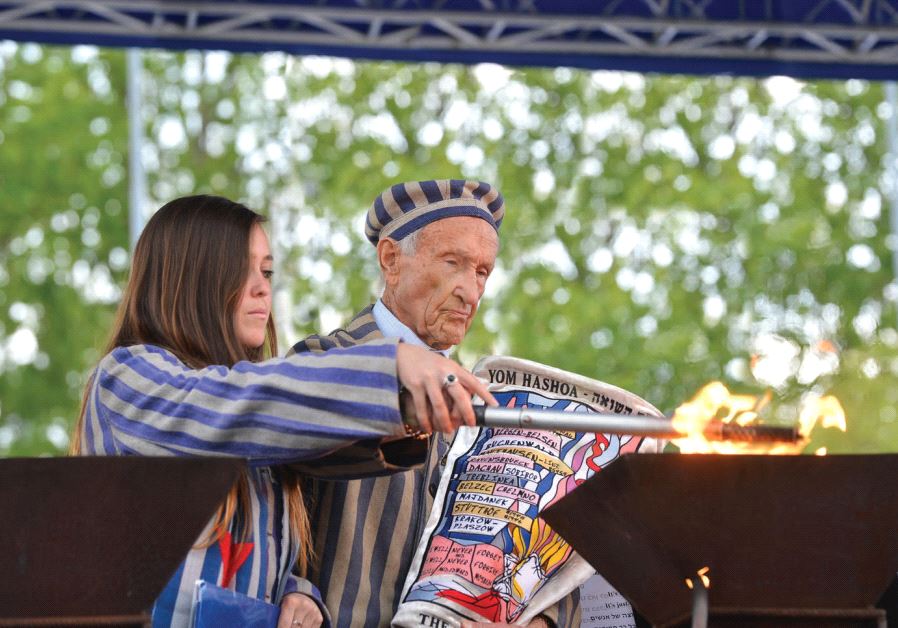 Survivor Edward Mosberg lights a memorial torch with his granddaughter on the 2016 March of the Living
