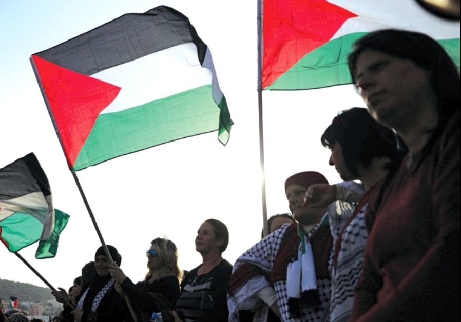 Israeli Arabs raise Palestinian flags at a Land Day rally, March 30