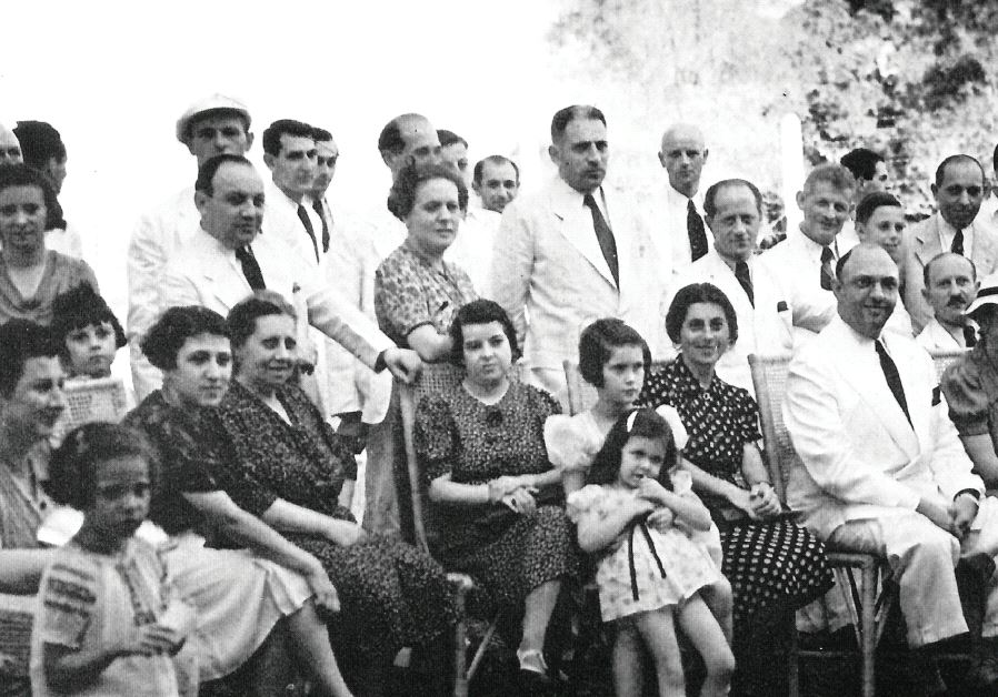 Cigar maker and rescuer Alex Frieder (seated at center middle), brother of Herbert, sits among Jewish refugees