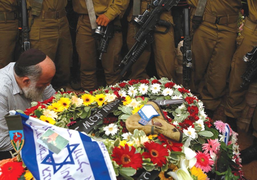 SOLDIERS STAND next to the grave of their comrade Lieutenant Hadar Goldin during his funeral in Kfar Saba in August 2014
