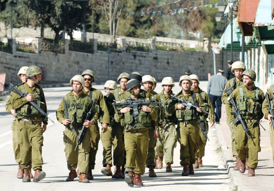 IDF soldiers patrol after clashes with Hebron Jews seeking to thwart evacuation from the city’s wholesale market in 2006
