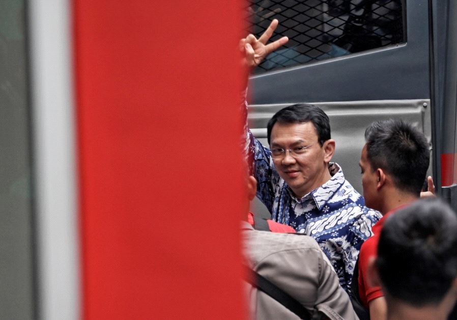 Jakarta's first non-Muslim governor Basuki Tjahaja Purnama raises his hand as he arrives at the Cipinang prison in Jakarta, Indonesia May 9