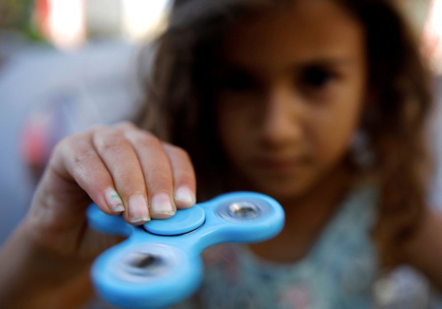 A girl performs tricks using a fidget spinner during a contest held in Ashdod, Israel May 11, 2017