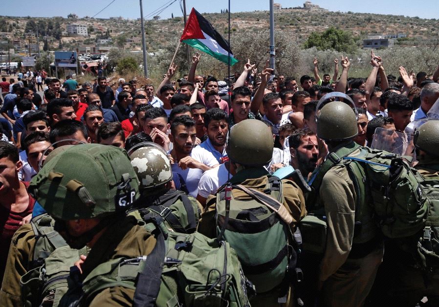 SOLDIERS TUSSLE with Palestinians in the West Bank village of Beita
