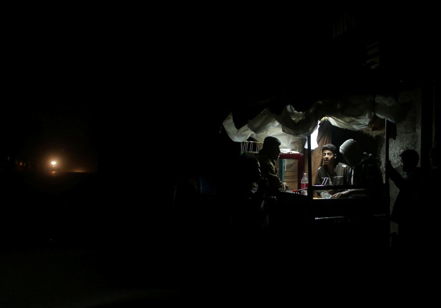 A Palestinian man sells falafel in a makeshift shop lit with a lamp powered by a battery during a power cut in Beit Lahiya in the northern Gaza Strip January 11, 2017. Picture taken January 11, 2017. 