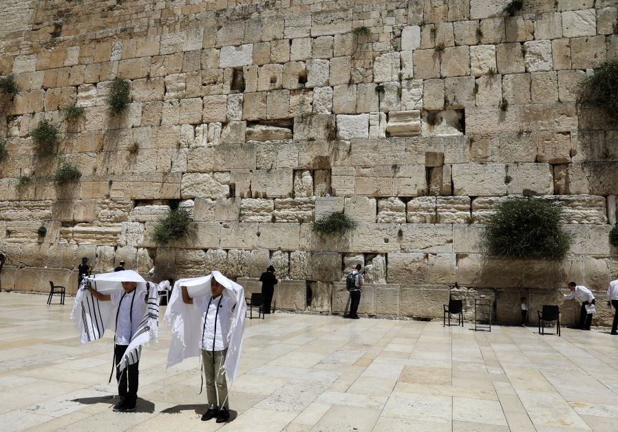 Youth hold their prayer shawls as they stand in front of the Western Wall, Judaism's holiest prayers site in Jerusalem's Old City May 17, 2017.