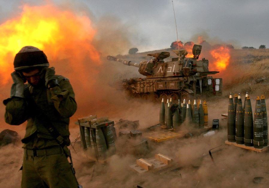 An Israeli soldier stands near a mobile artillery unit as it fires a shell into southern Lebanon from its position in Zaura, northern Israel, in this July 13, 2006 file picture. 