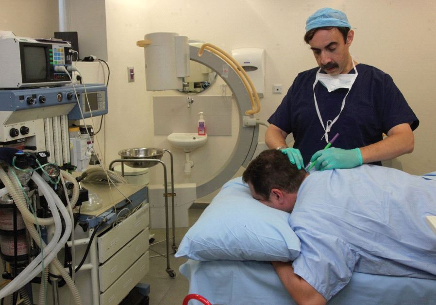 AN ISRAELI DOCTOR examines a patient in this illustrative photo.