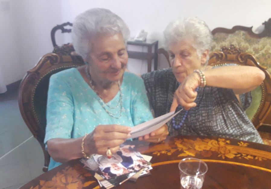 PROF. ALESSANDRA STADERINI (right), daughter of Fausto and Bice who sheltered their Jewish friends’ children Bianca Campagnano (left) and her brother in their home in Rome during the Nazi occupation of Italy. The two women look through family photos at LUMSA University in Rome on June 27