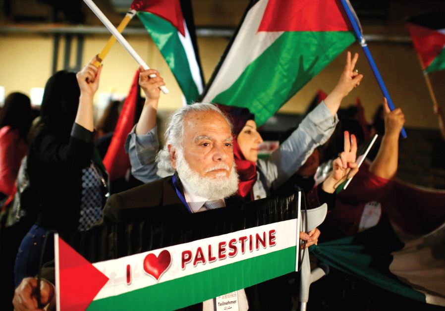 PEOPLE HOLD Palestinian flags during the Conference of Palestinians in Berlin in 2015.
