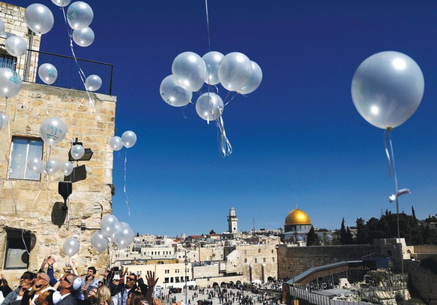 Visitors release balloons as they begin celebrating a bar mitzva near the Western Wall in Jerusalem in February