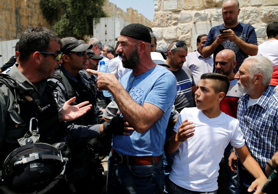 A Palestinian argues with an Israeli border police officer during scuffles that erupted after Palestinians held prayers just outside Jerusalem's Old City in protest over the installation of metal detectors placed at an entrance to the Temple Mount, July 17, 2017. 