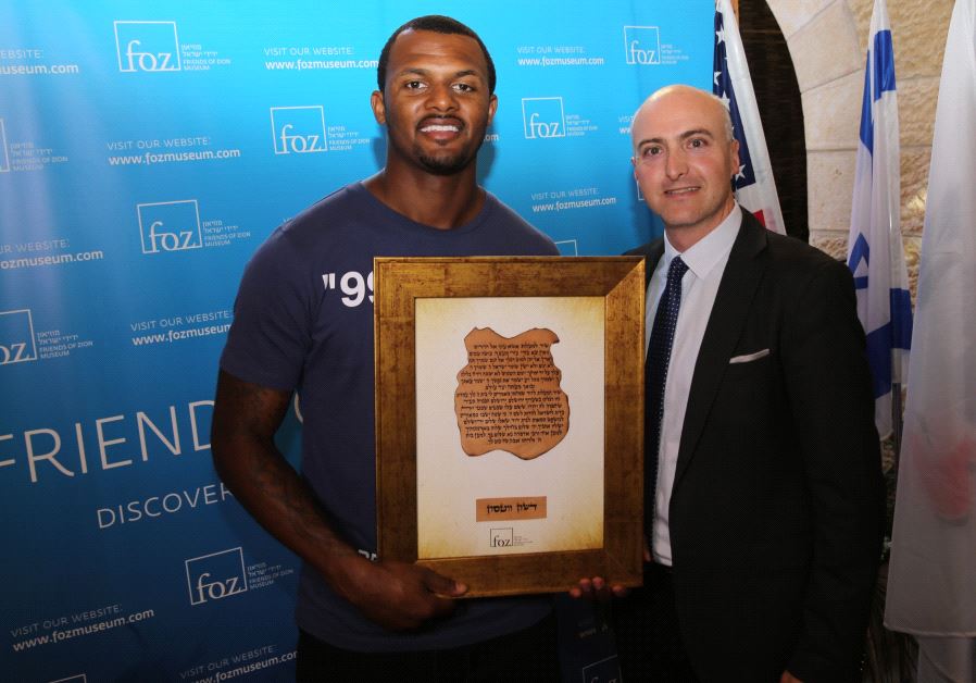 NFL Pro-Bowl quarterback Deshaun Watson receives an award from Friends of Zion Museum's Ilan Scolnik